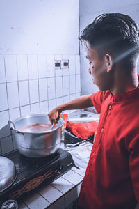 Side view of man preparing food at home