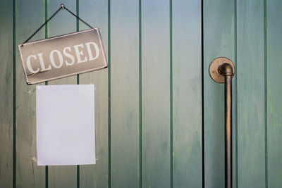 Close-up of information sign on wooden door