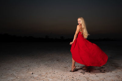 Young blond woman in red clothing posing and doing modeling on the salt lake of larnaca
