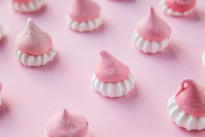 Pink and white meringues stand on a pink background, background picture