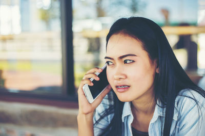 Portrait of young woman using mobile phone