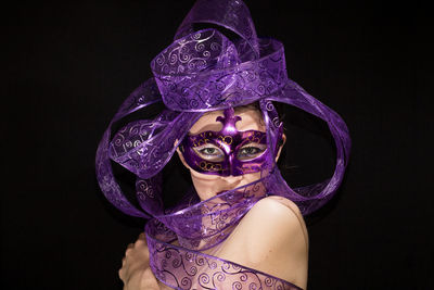 Portrait of woman against black background