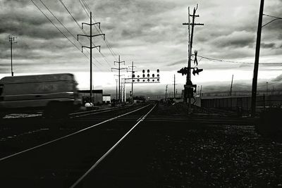 Railroad tracks against cloudy sky