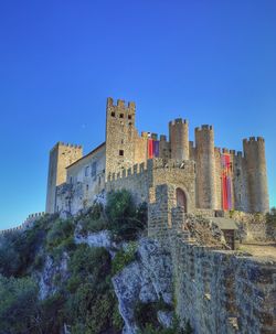 Low angle view of old ruins against clear blue sky