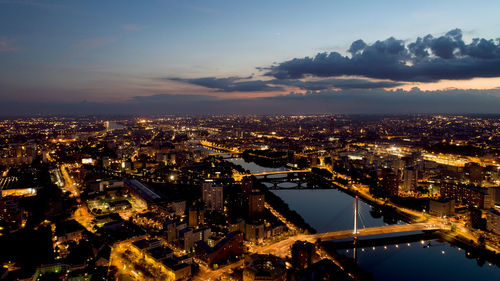 High angle view of illuminated city against sky at night