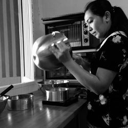 Side view of woman preparing food at home