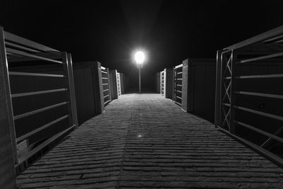 Narrow walkway along illuminated building at night