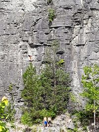 People on rock by road