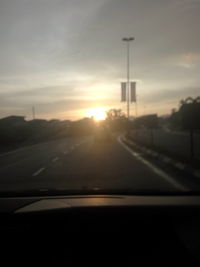 Car on road against sky during sunset