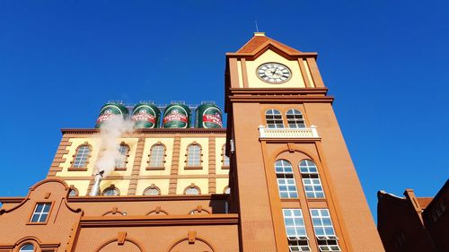 Low angle view of clock tower against clear blue sky