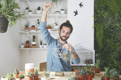 Portrait of young man holding food on table