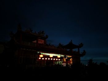 Low angle view of illuminated building against sky at night