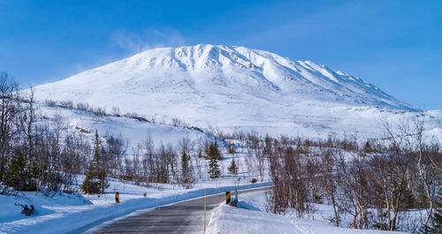 Scenic view of snowcapped mountains against blue sky
