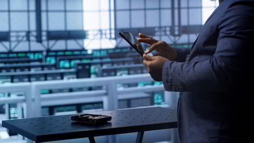 Midsection of businessman using mobile phone