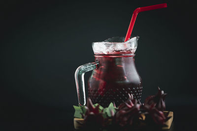 Close-up of glass jar against black background