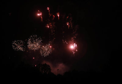 Low angle view of firework display at night