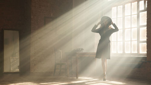 Woman standing by window at home