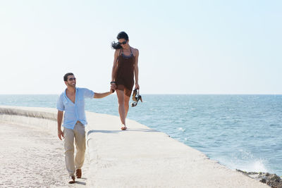 Woman on beach against clear sky