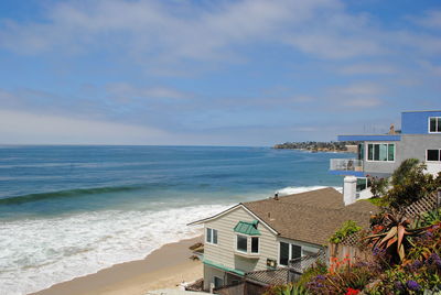 Scenic view of beach by buildings against sky