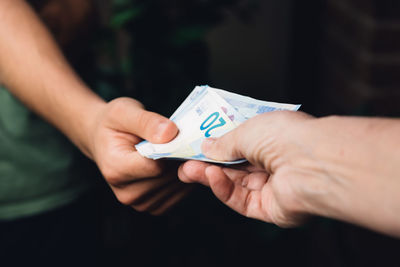 Cropped image of hands holding paper currency