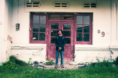 Full length of man standing outside house against building