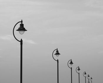 Low angle view of street lights against sky