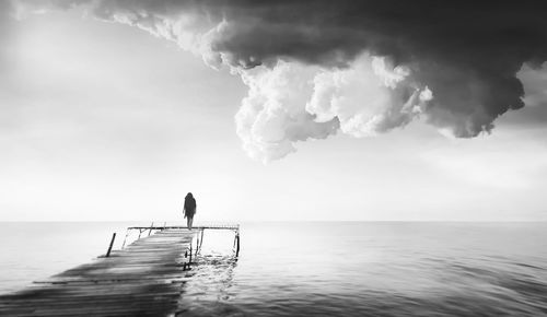 Man surfing in sea against sky