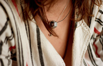 Midsection of woman wearing nut pendant