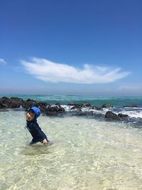 Portrait of girl wading in sea against sky
