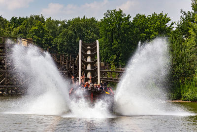 People riding on roller coaster in water park