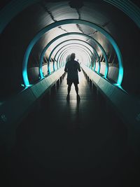 Rear view of man standing in tunnel