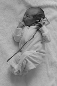 Directly above shot of baby with rose on bed at home