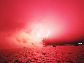 Scenic view of illuminated sea against sky at night