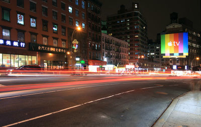 Light trails on road along buildings at night