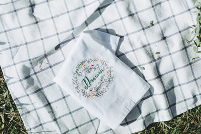 Directly above view of napkin with text on picnic blanket at park