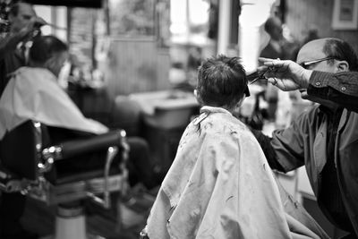 Barber cutting hair of boy