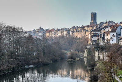 River amidst buildings in town against clear sky