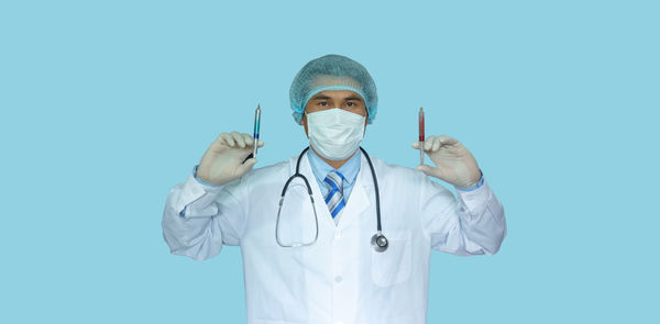 Portrait of man standing against blue background