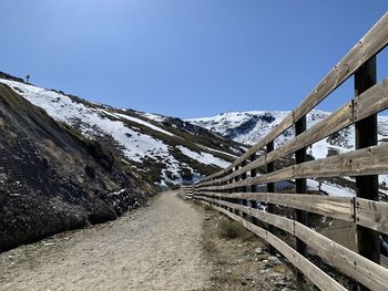 Snow covered footbridge against clear sky