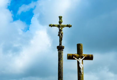 Low angle view of cross against cloudy sky