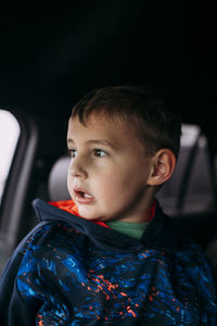 Boy waiting for friends inside car and looking out window in texas