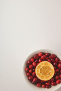 Directly above shot of fruits in bowl against white background