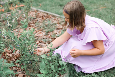 Side view of woman sitting on field