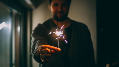 Man holding illuminated light in the dark