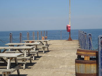 Wooden pier on sea against clear sky