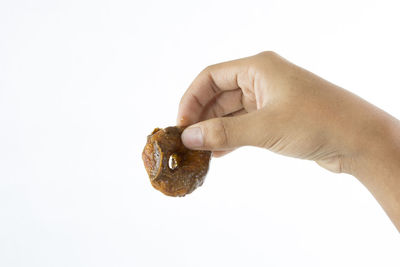 Close-up of hand holding ice cream over white background