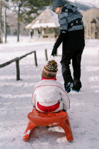 Rear view of people walking on snow