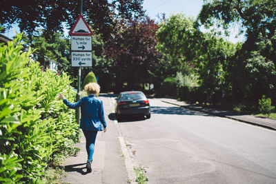 Rear view of man walking on road