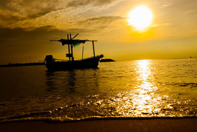 Silhouette boat in sea against sky during sunset