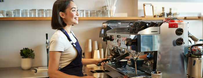 Portrait of young woman standing in kitchen